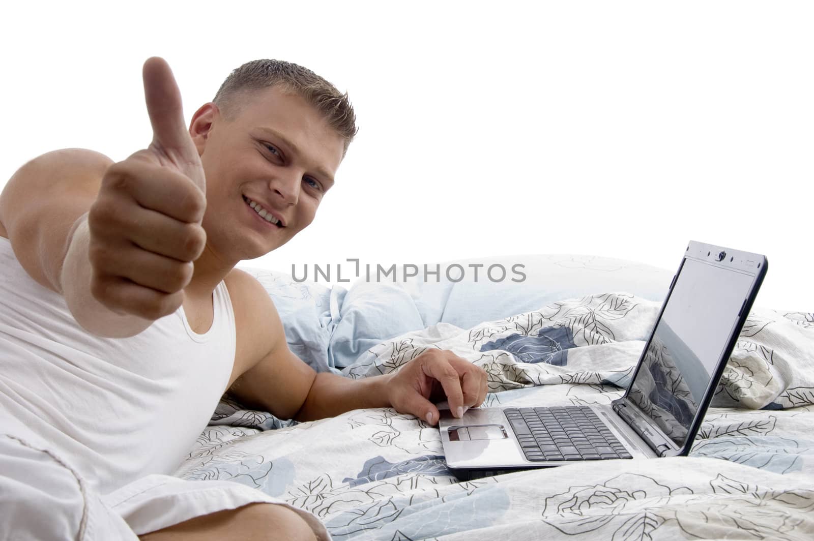 man with laptop and thumbs up in bed