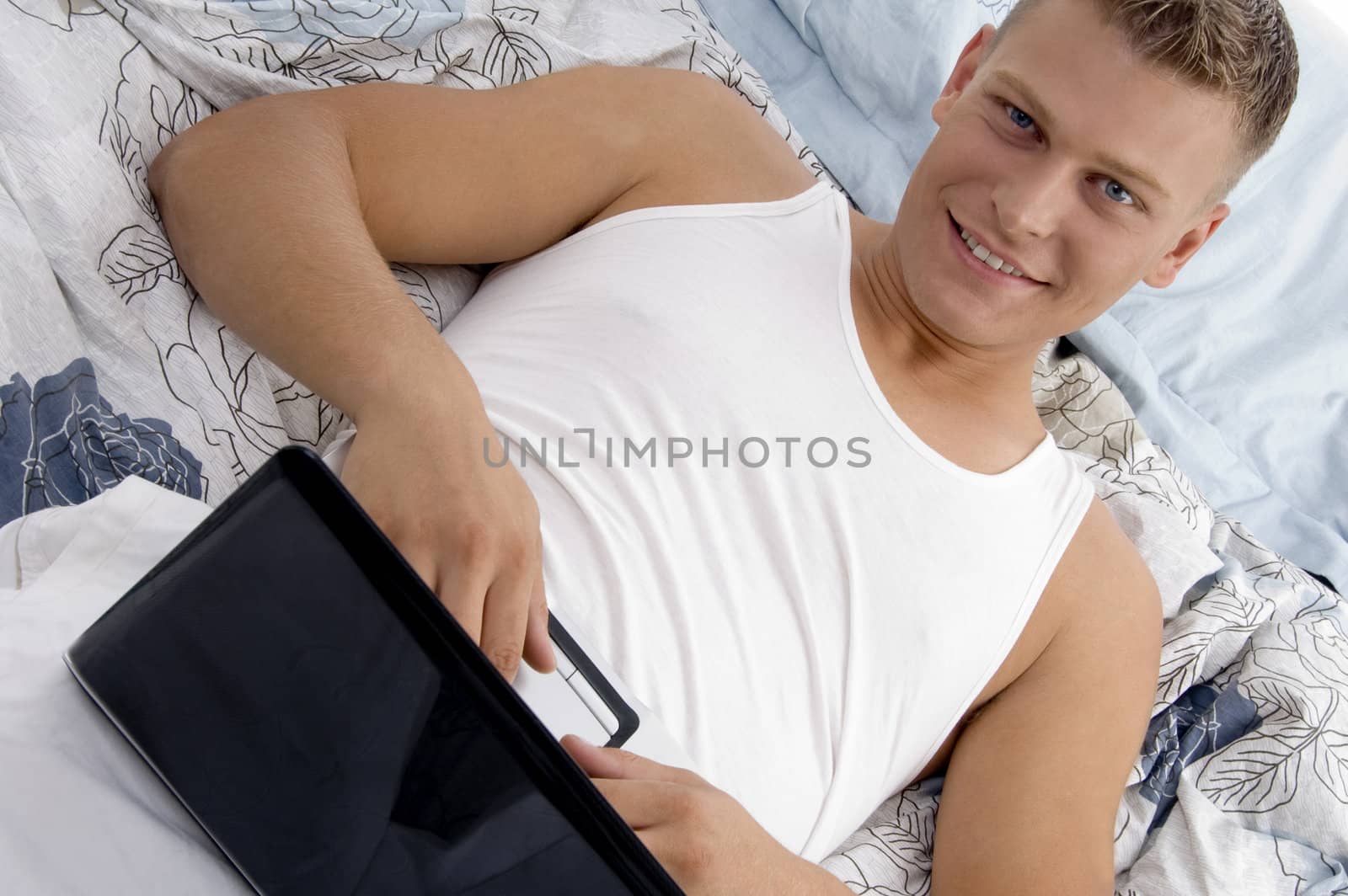 male putting laptop on his stomach by imagerymajestic