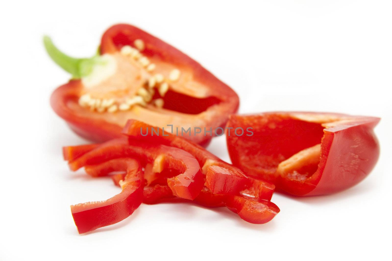 Sliced red pepper (foreground) isolated on a white background