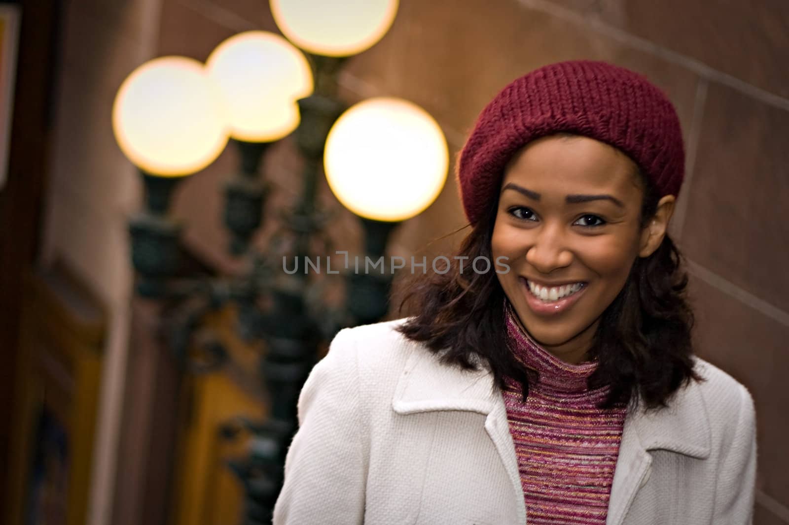 An attractive African American business woman posing outdoors in the city.