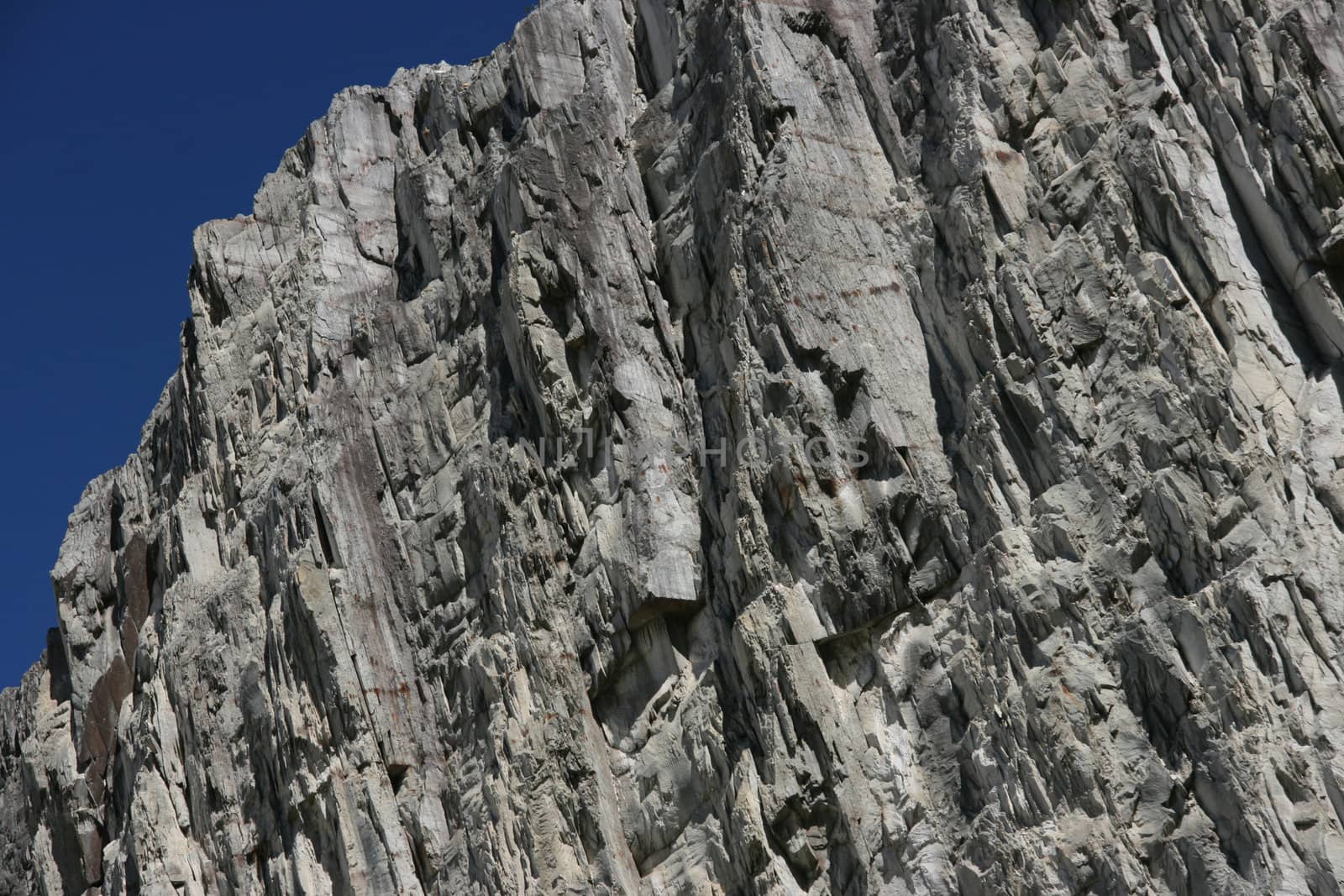 Canadian Rocky Mountains - mountain wall stone background with a piece of sky