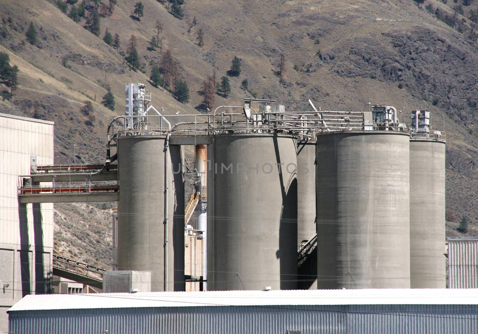 Cement factory in Canada with background mountains.