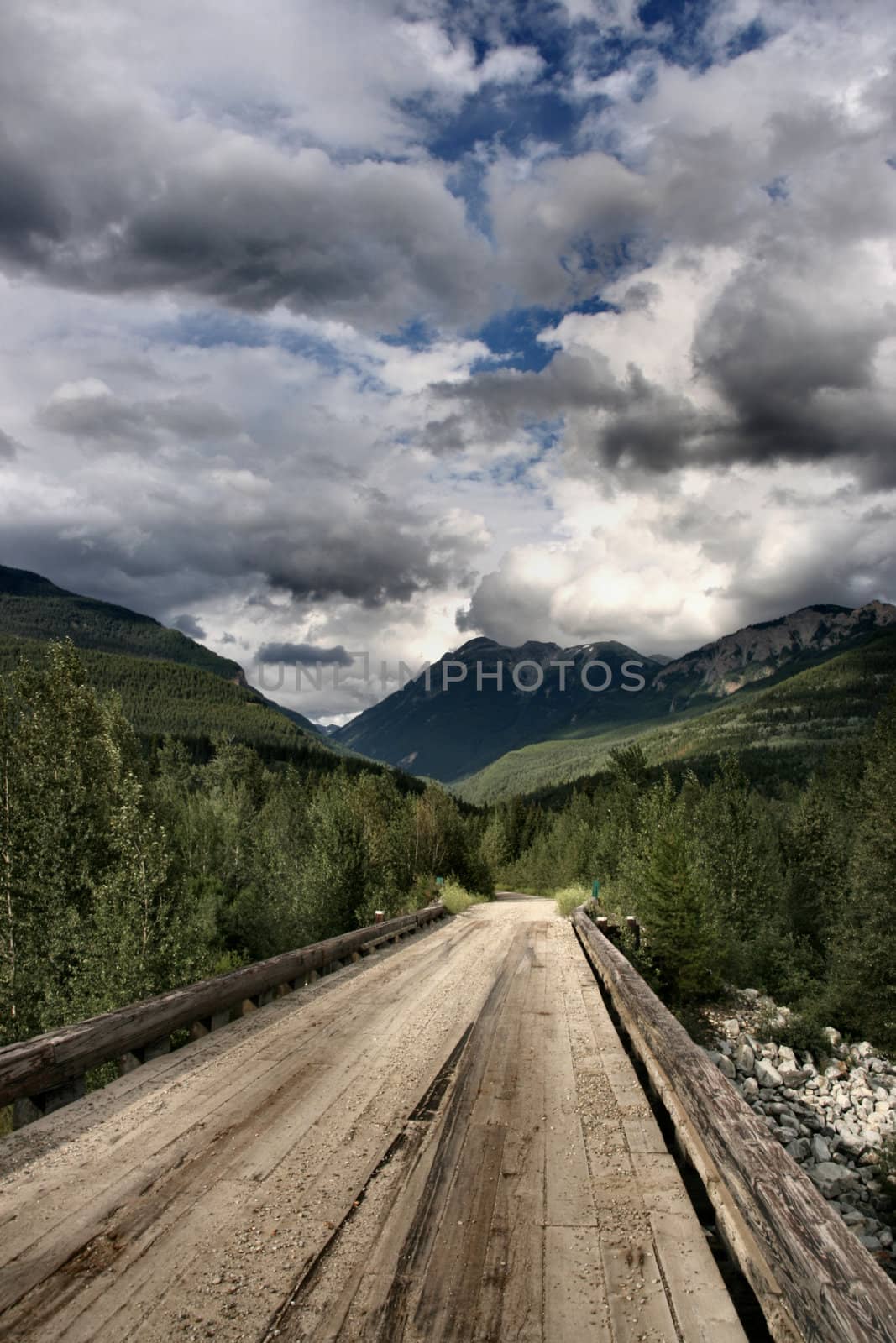 Wooden bridge and beautiful mountain landscape of Rocky Mountains in Canada. Near Kinbasket lake.