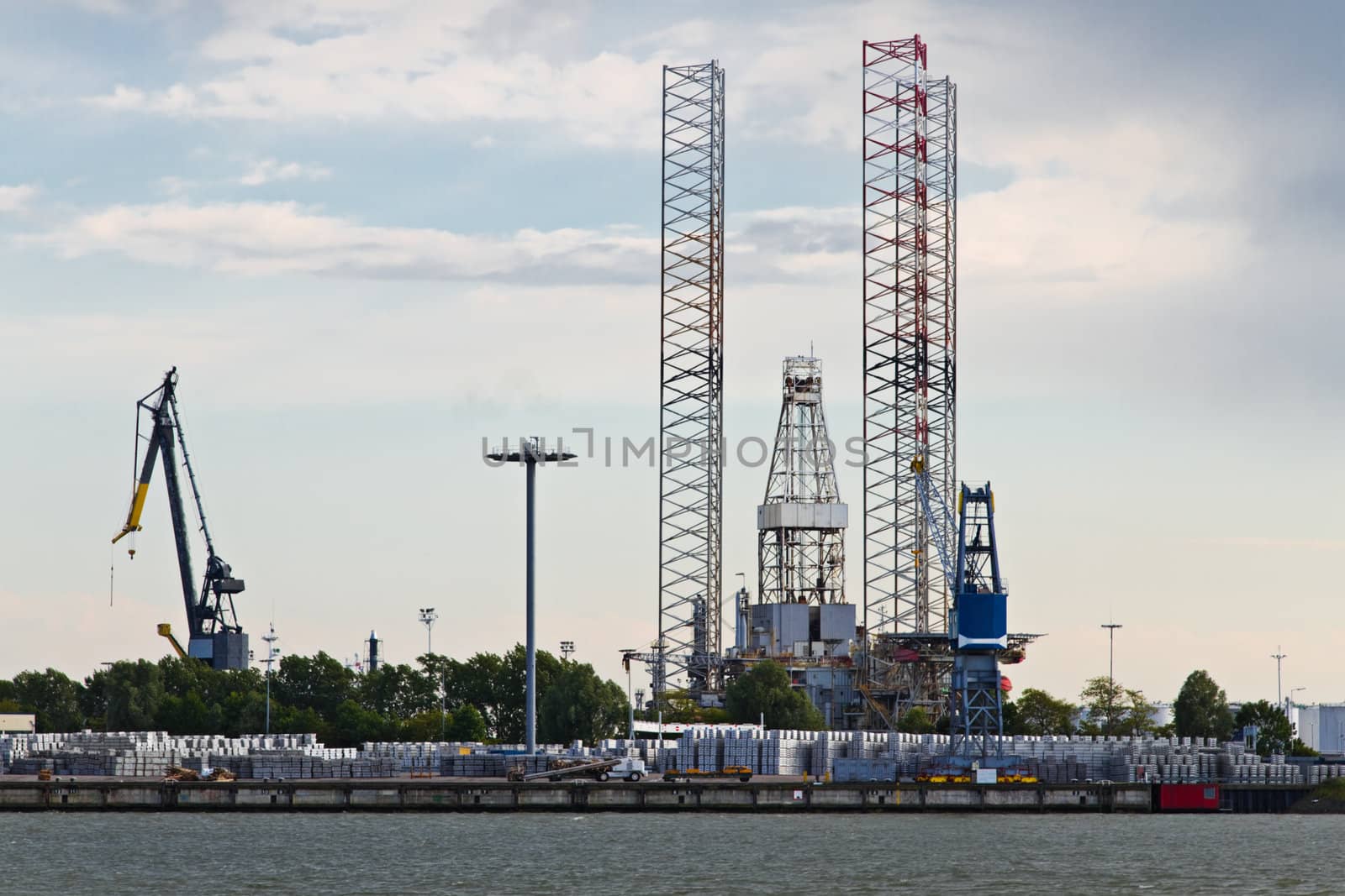 Industrial cranes and drilling platform in dock at the riverside