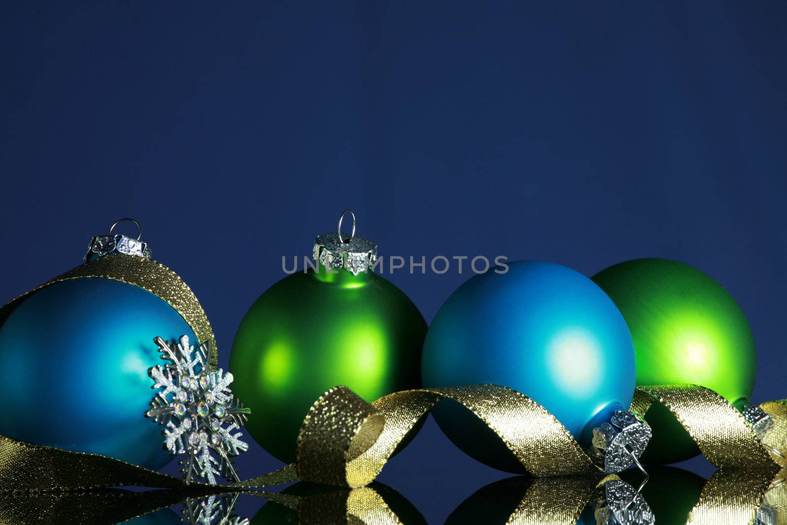 Christmas ornaments and gold ribbon on dark blue background, focus ob blue ball and ribbon