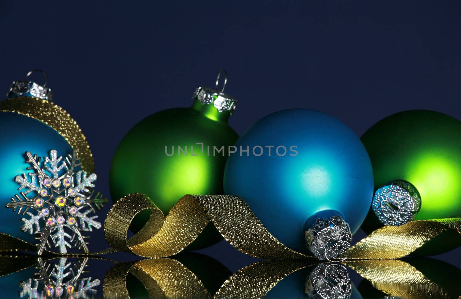 Christmas ornaments and gold ribbon on dark blue background, focus ob blue ball and ribbon