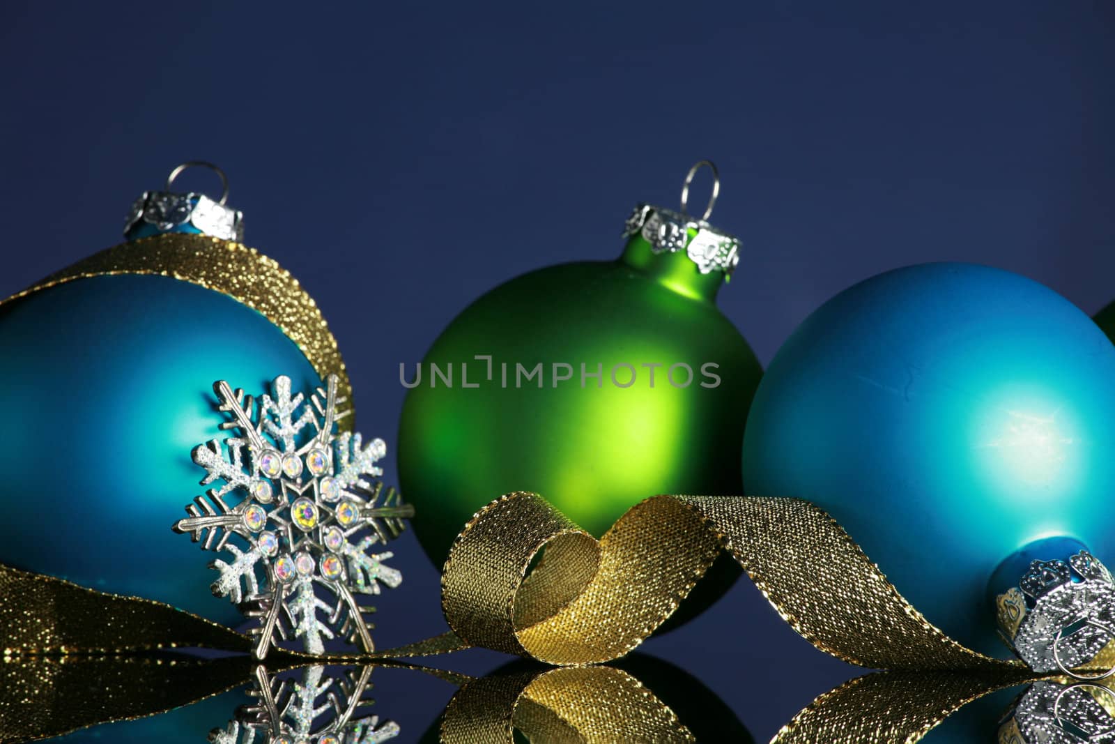 Christmas ornaments and gold ribbon on dark blue background, focus ob blue ball and ribbon