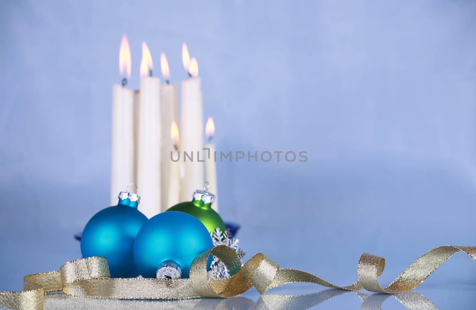 Christmas decoration on soft blue cloth, focus on blue ball and gold ribbon