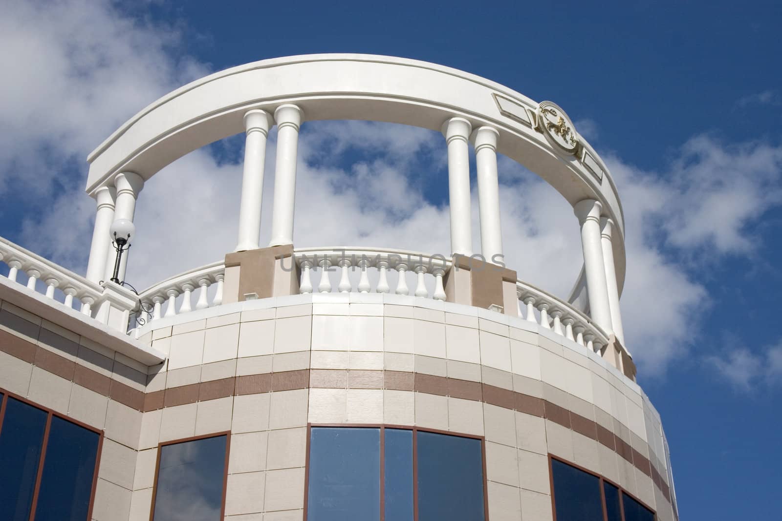 Balcony with white columns on a background of the sky with clouds.