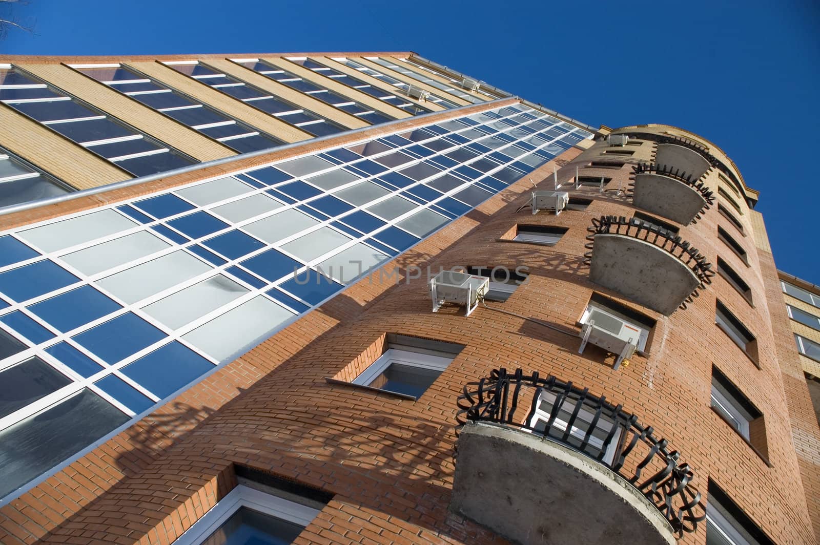 Modern building from a brick. Glass balconies.