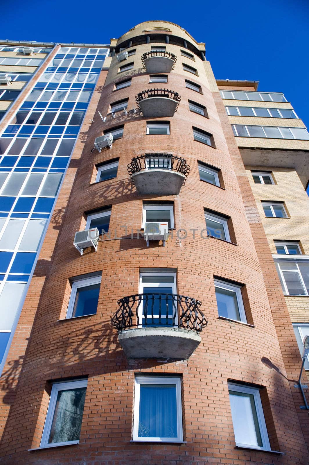 Modern building from a brick. Glass balconies.