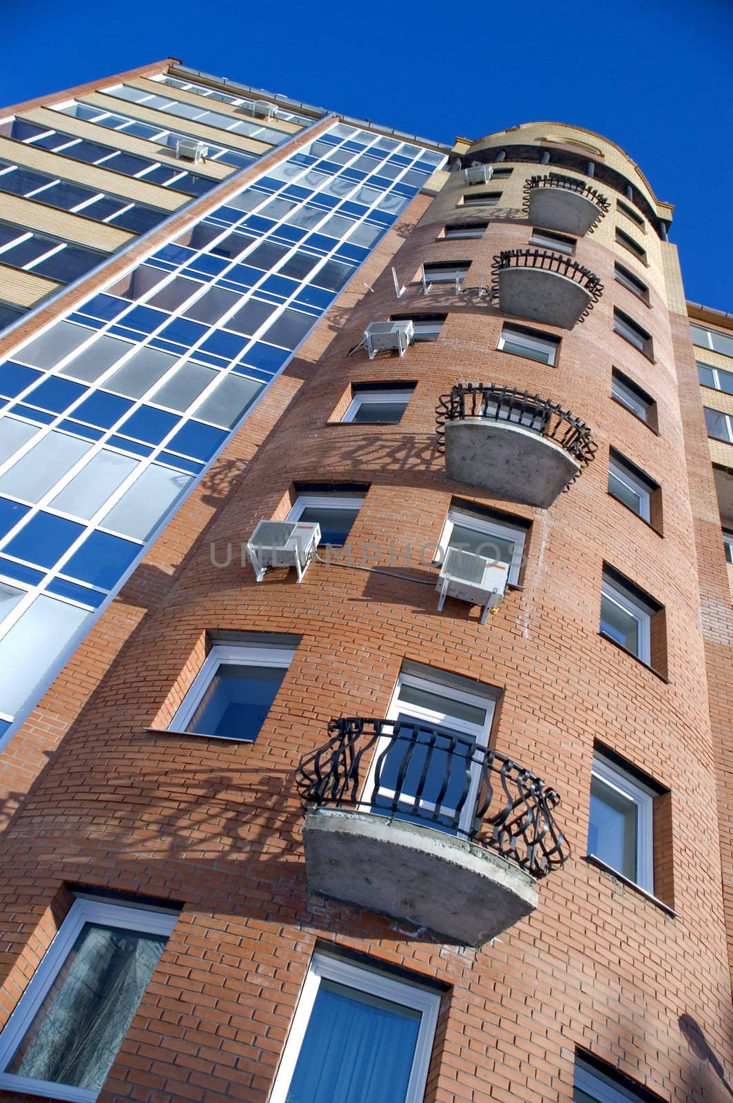 Modern building from a brick. Glass balconies.