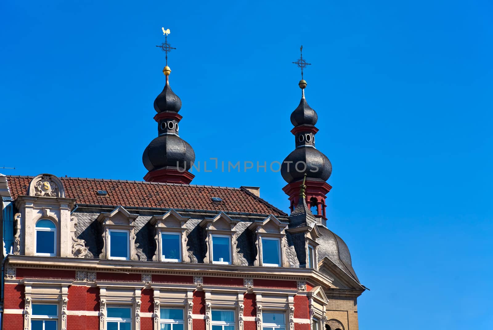 Old Architecture in Koblenz, Germany. Towers of the Church of Our Lady (Liebfrauenkirche) and a tenement house in the downtown.