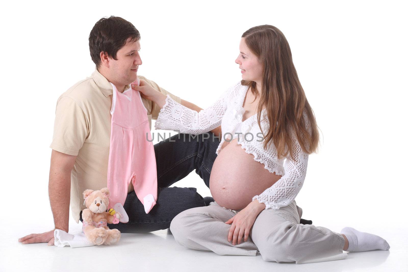 Couple waiting for baby looking on baby clothes by shcheglov
