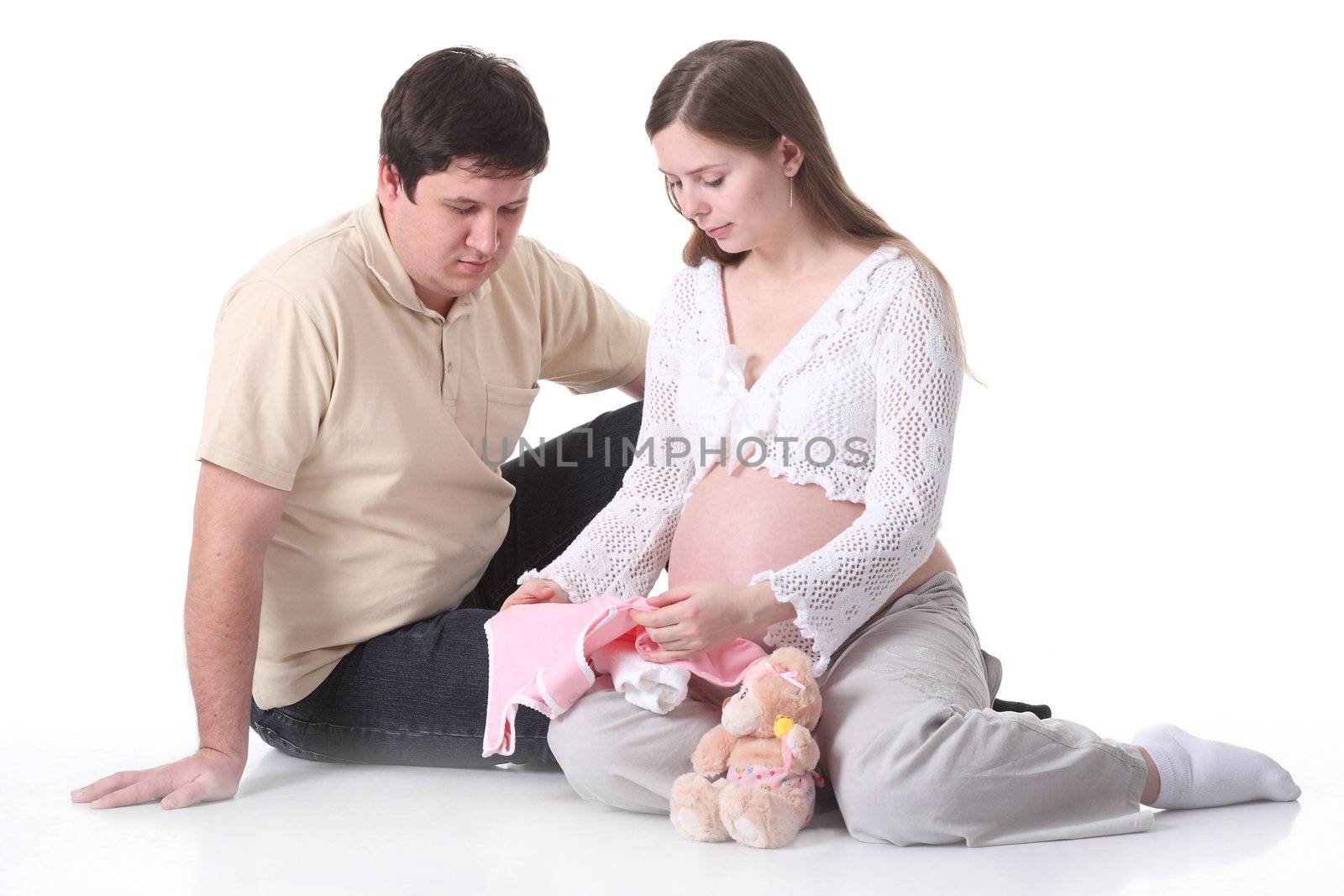Couple waiting for baby sitting and looking on baby clothes