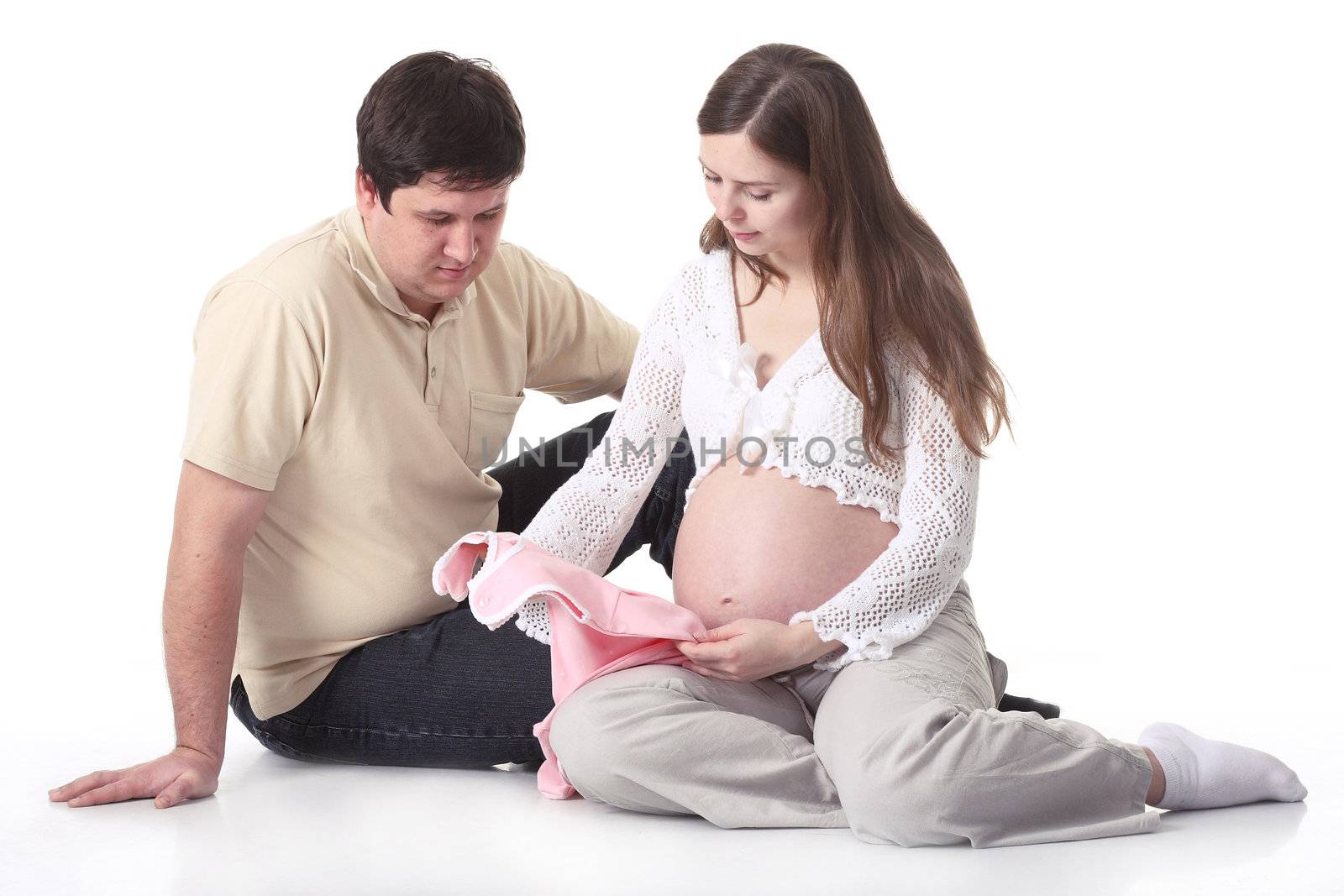 Couple waiting for baby sitting and looking on baby clothes