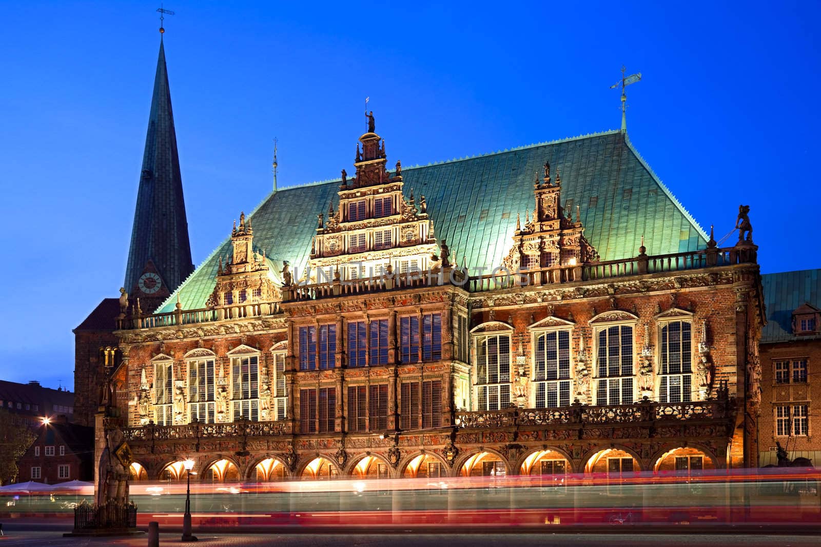 Townhall in Bremen at the blue hour. In the foreground a tram passing by. Long exposure - motion blur.