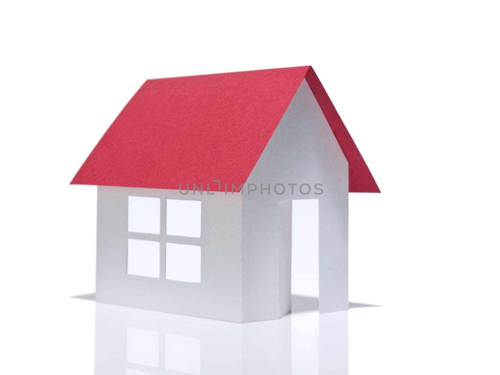 A paper house stands over a white background.