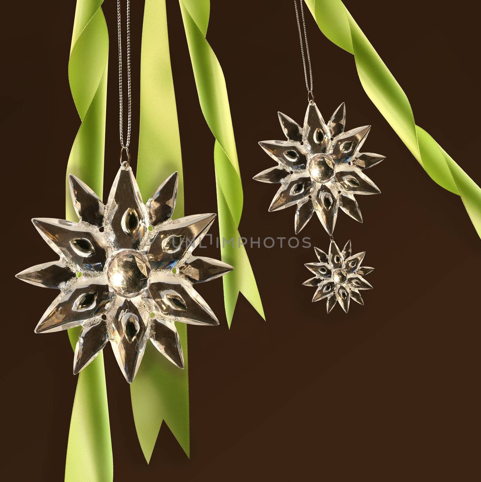 Crystal snowflakes with green ribbons on dark background