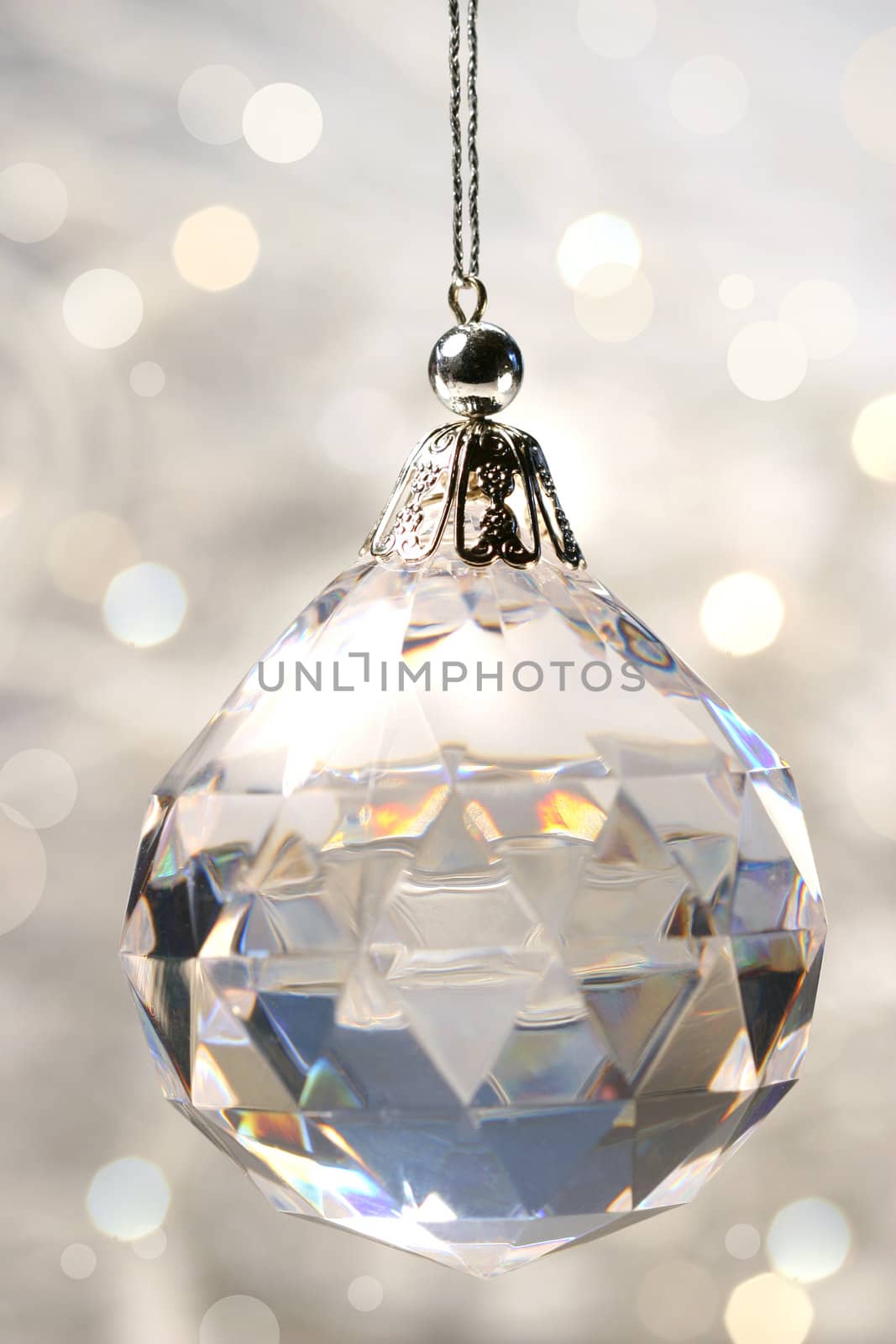 Crystal ornament hanging against shimmering background
