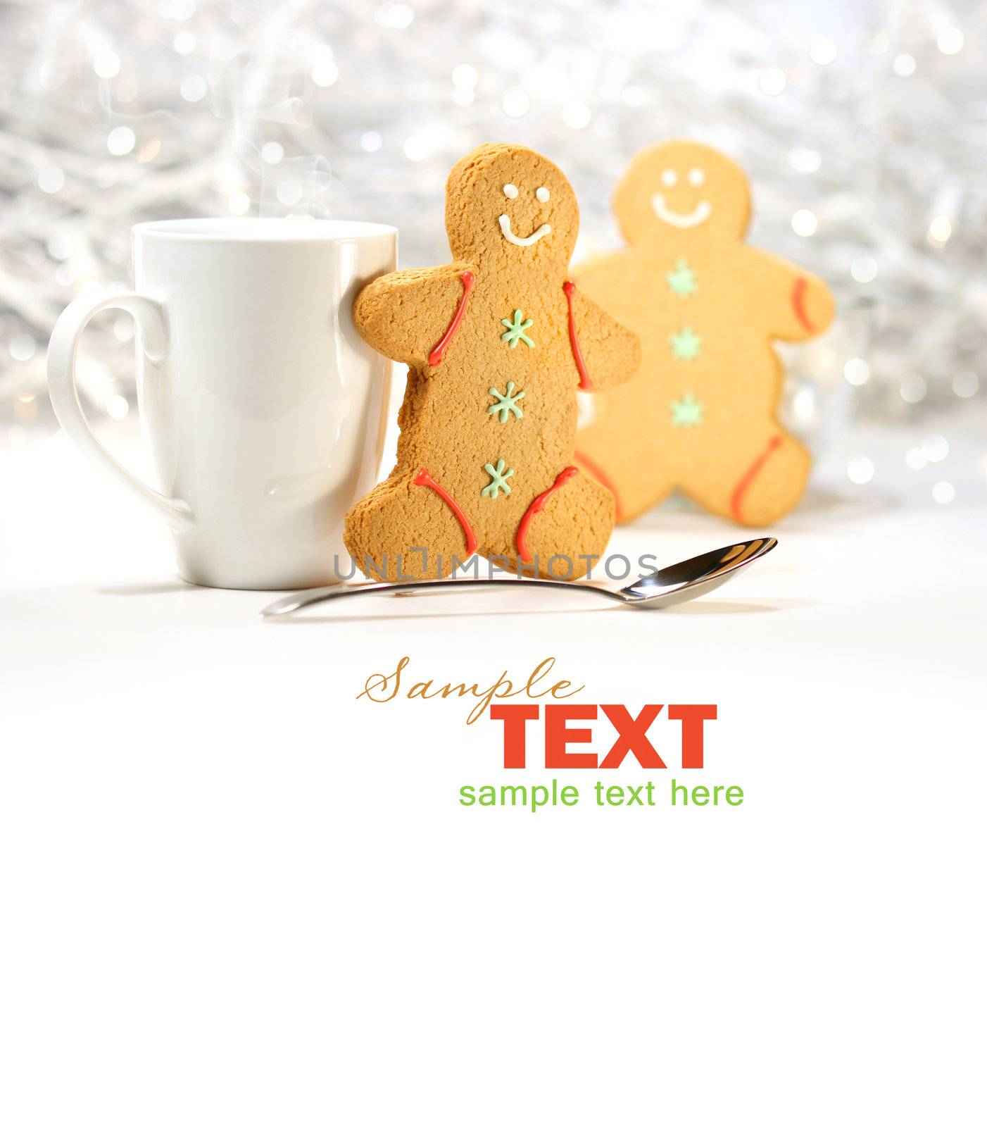 Hot holiday drink with gingerbread cookies on festive background