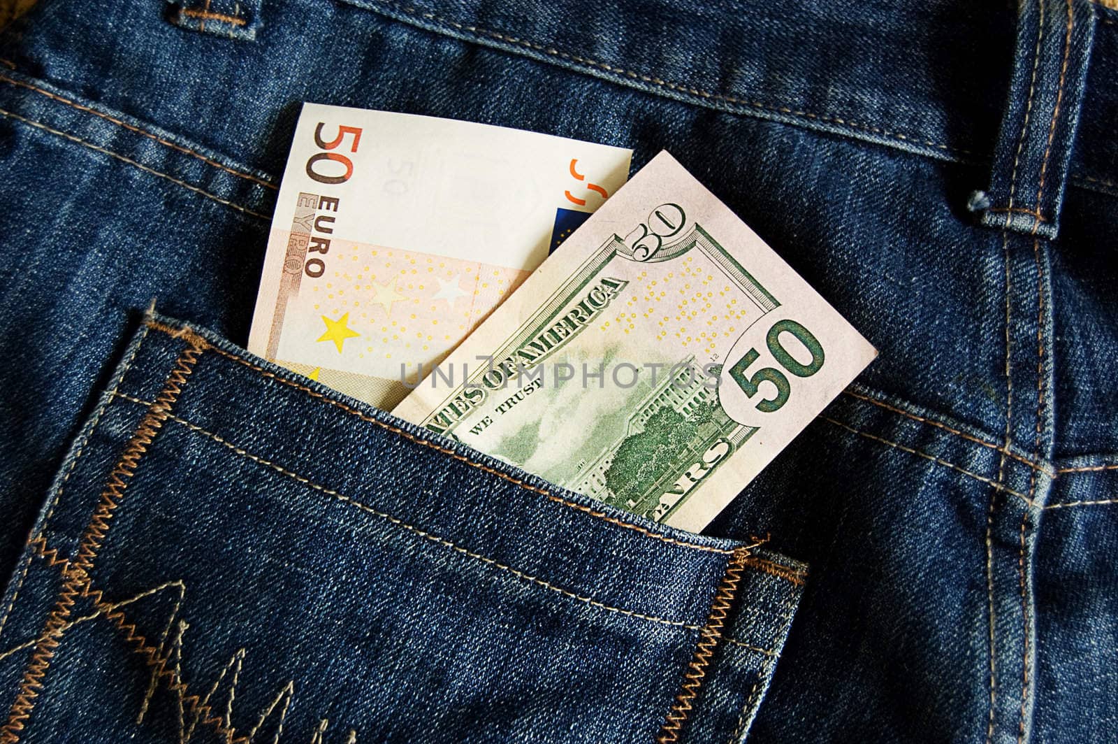 Fifty euro and dollar banknotes in jeans pocket