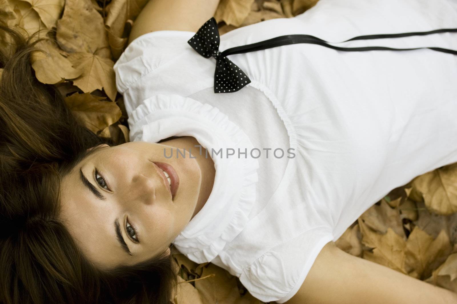 Young beautiful woman lying in the autumn park