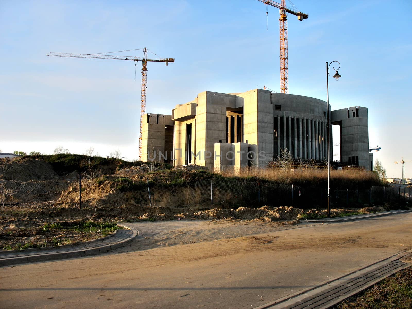 Photo presents a construction site with cranes in the background.