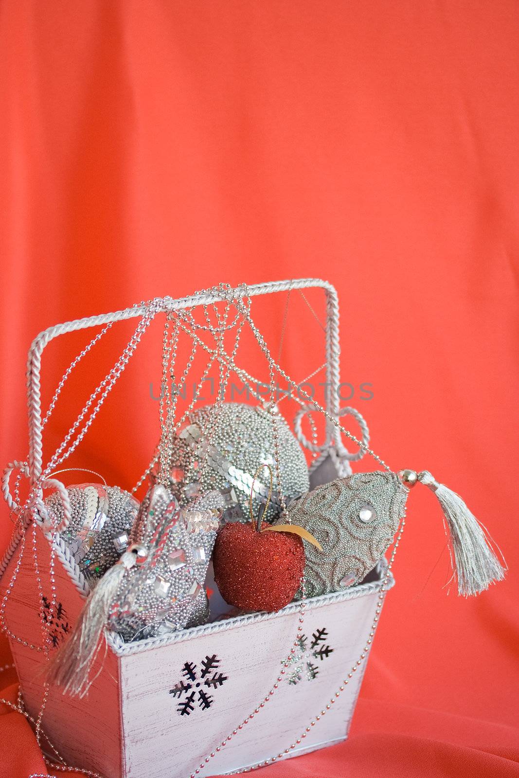 Red apple in box with silver christmas decoration on red