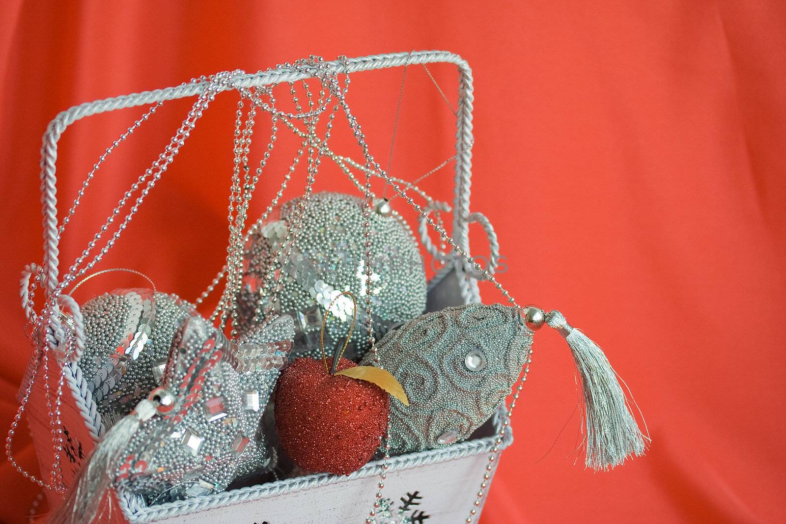 Closeup image of bag with christmas toys on red background. Selective focus