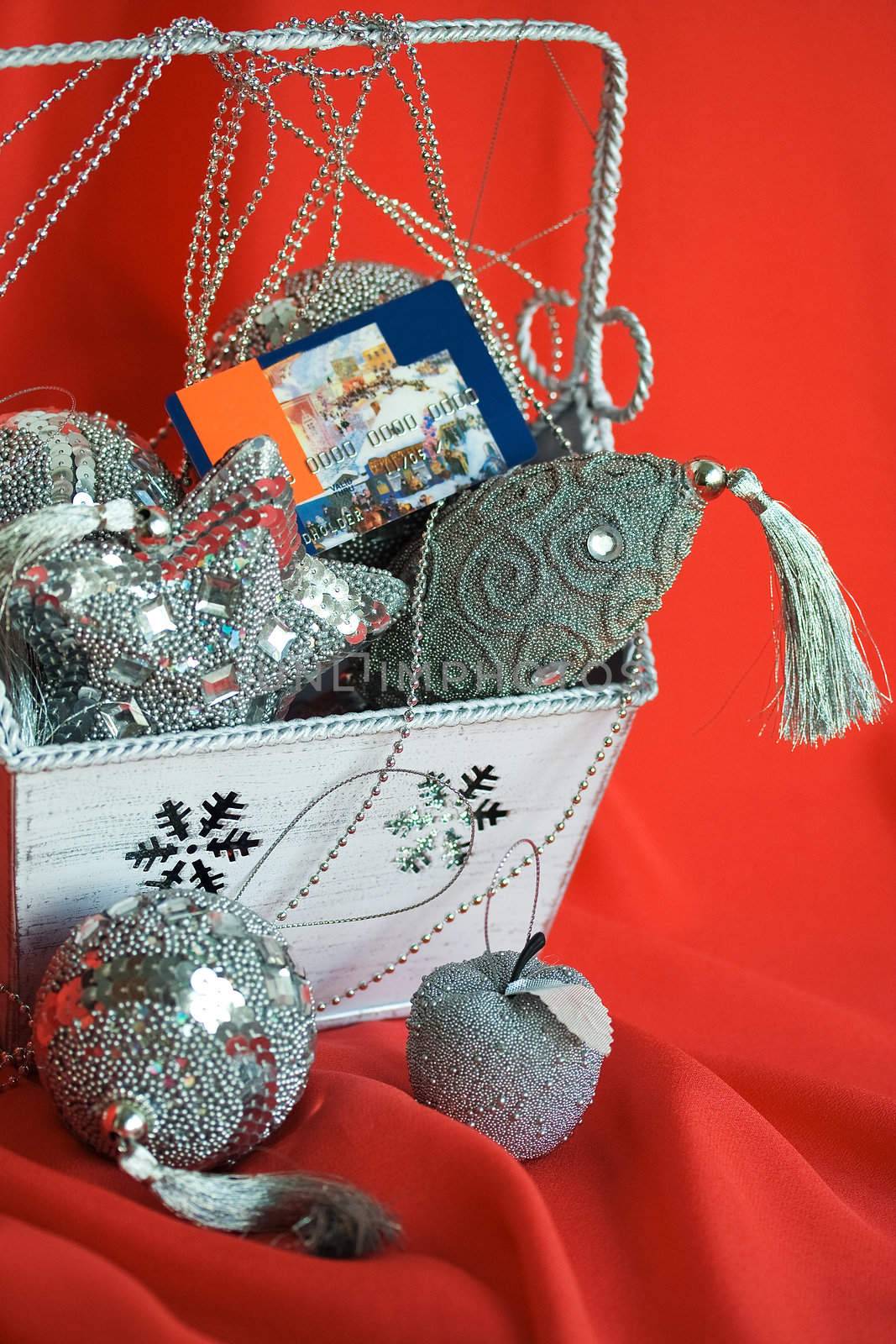 Closeup image of bag with christmas toys and credit card  on red background. Selective focus