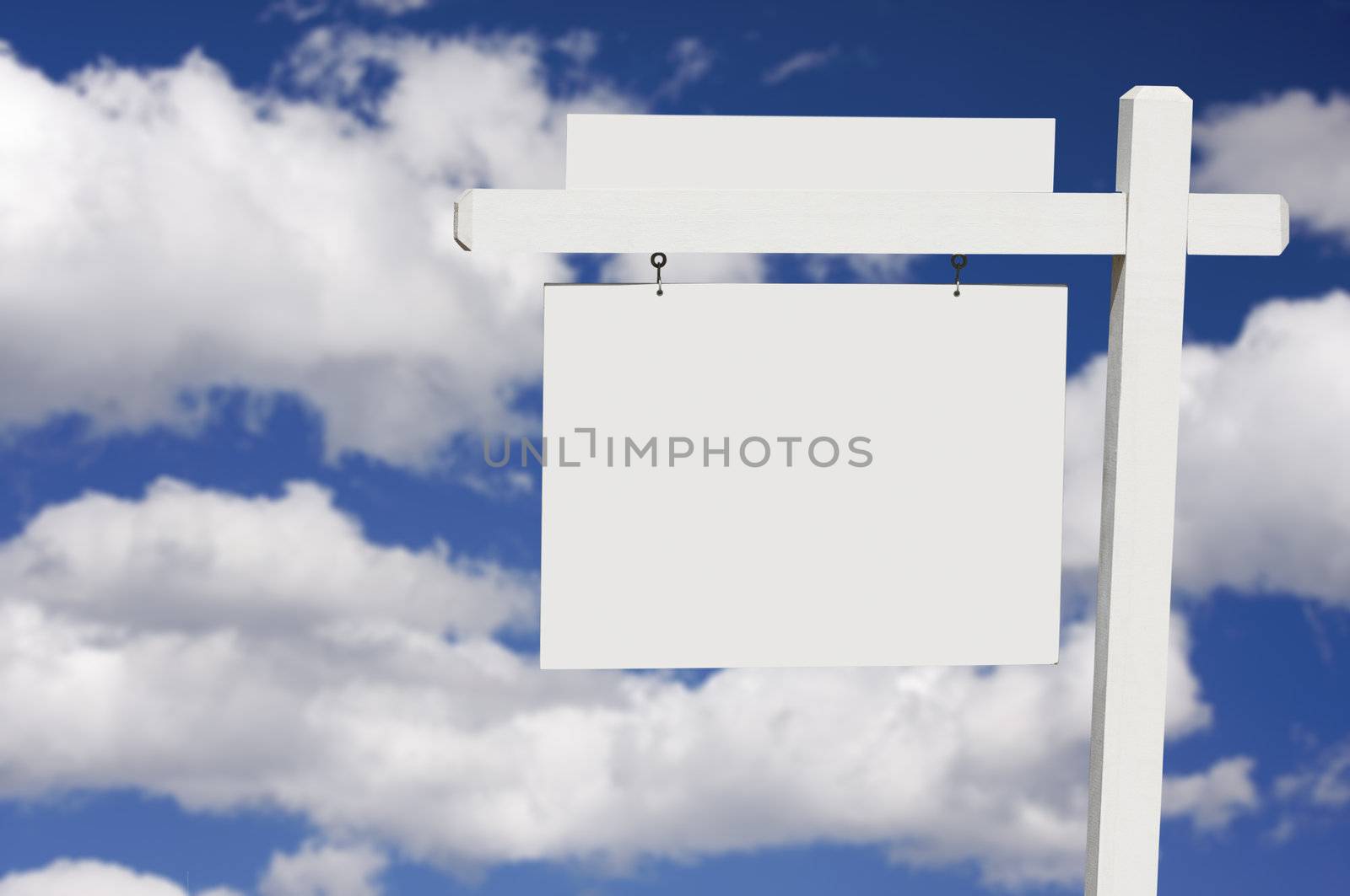 Blank Real Estate Sign on Clouds & Sky Background - Ready for your own message.