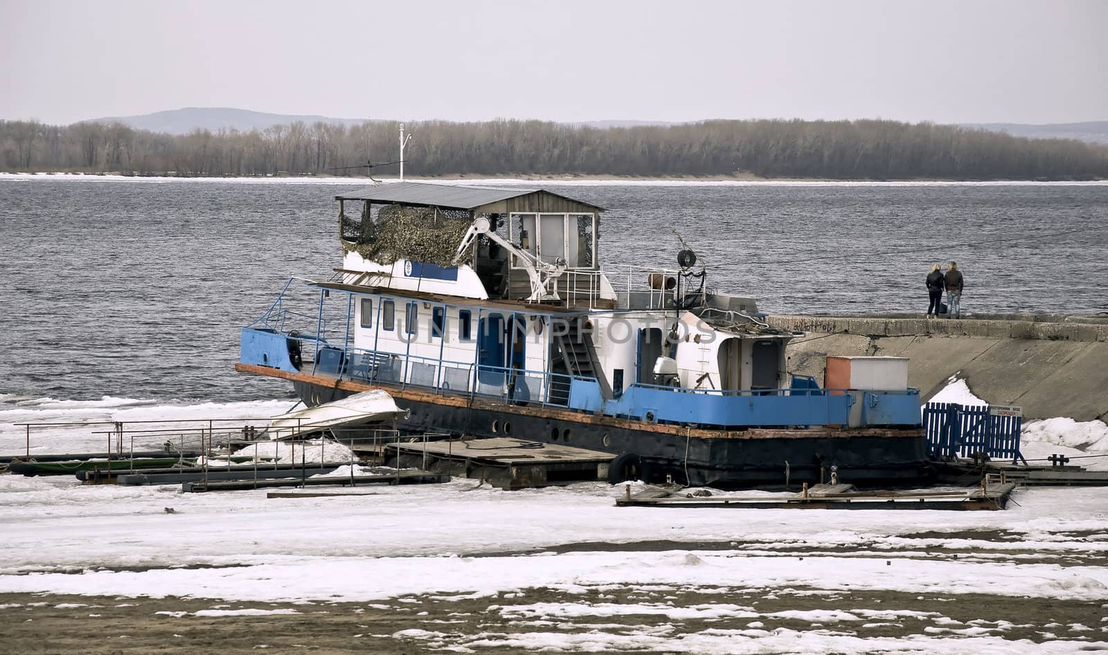 Frozen in the ice of the ship. Early spring tide left the ship on shore.