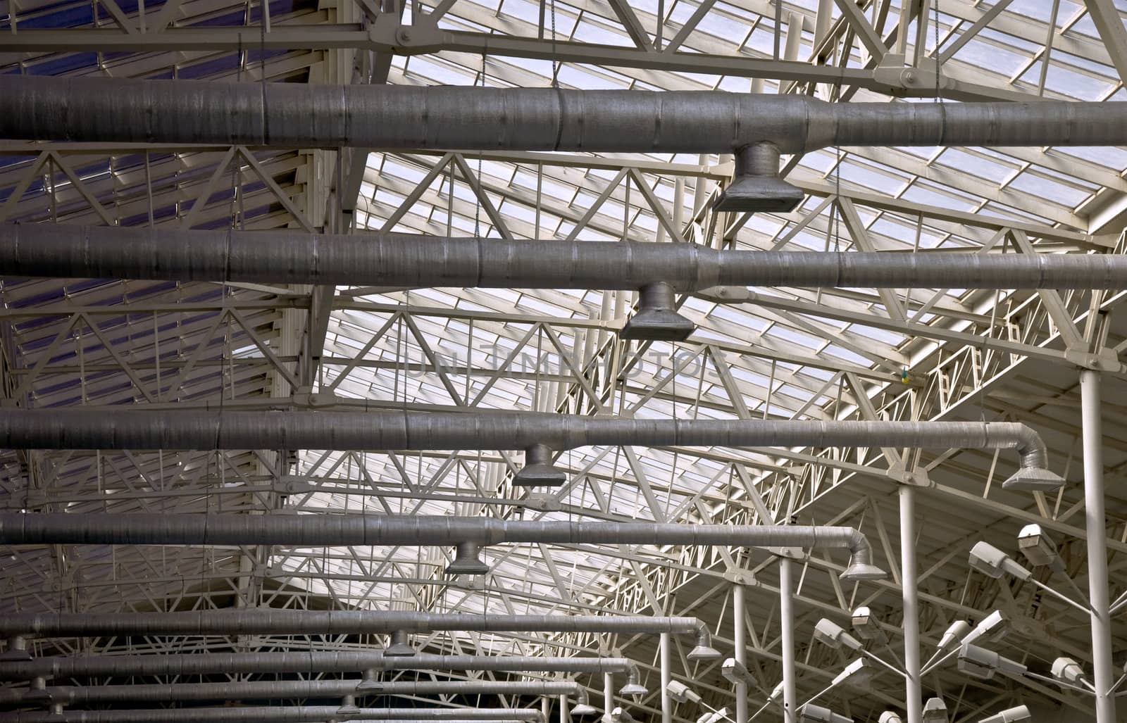 Frame of a metal truss. Roofs with top lighting. Part of the interior.