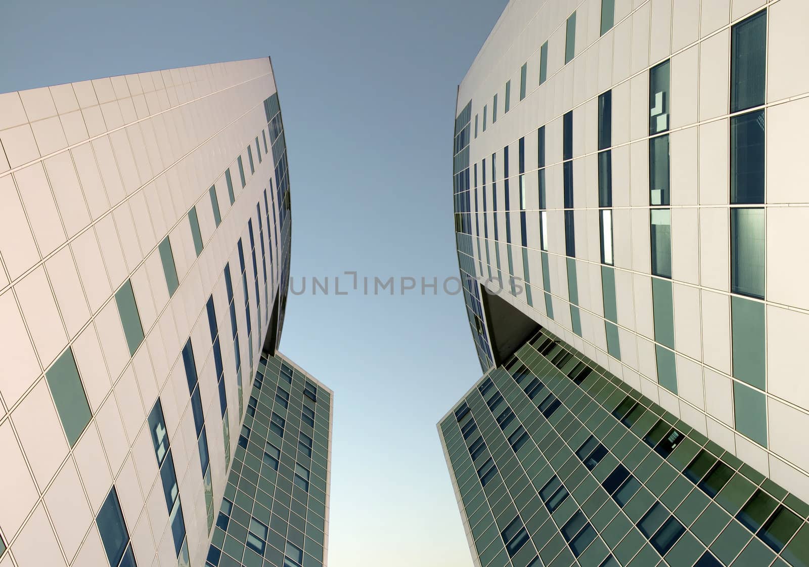 The glass facade of a skyscraper with the curtain walls on a background of blue sky.