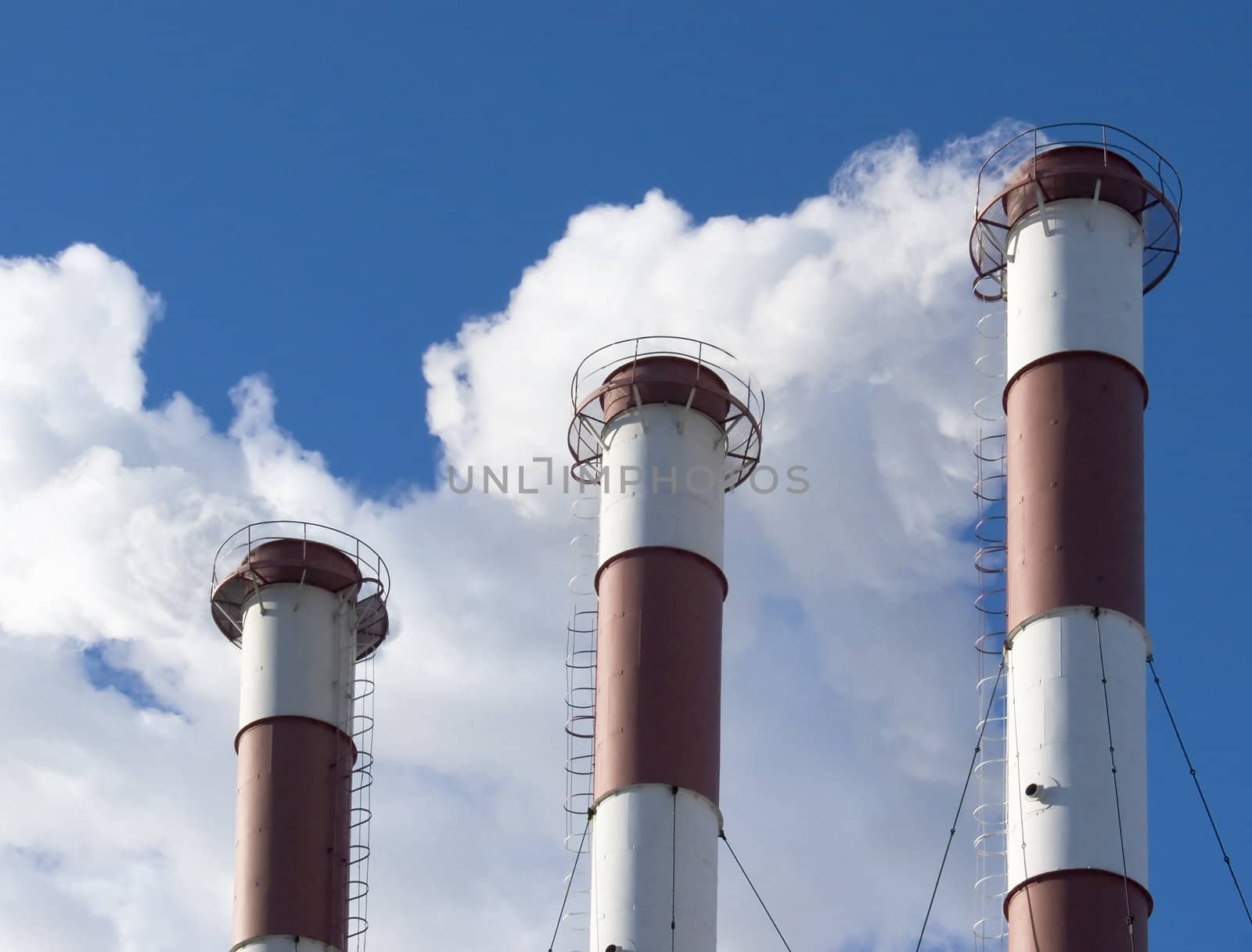 Industrial pipe and smoke them. Against the background of blue sky.