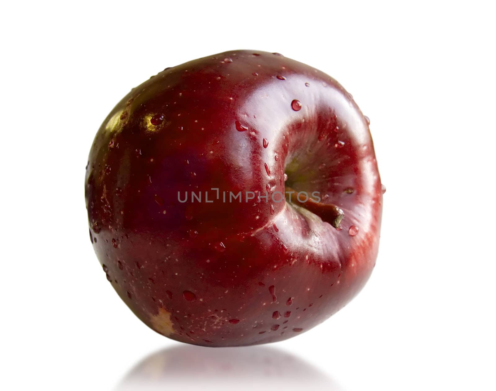 Ripe juicy apple with drops of water on a white background.