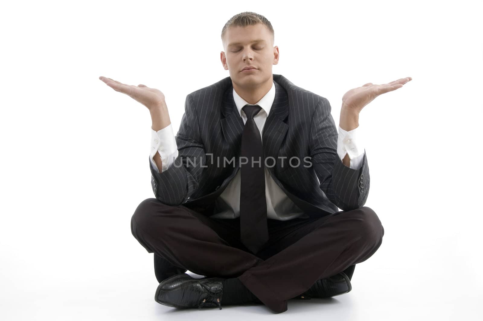 handsome young businessman doing yoga with open palms against white background