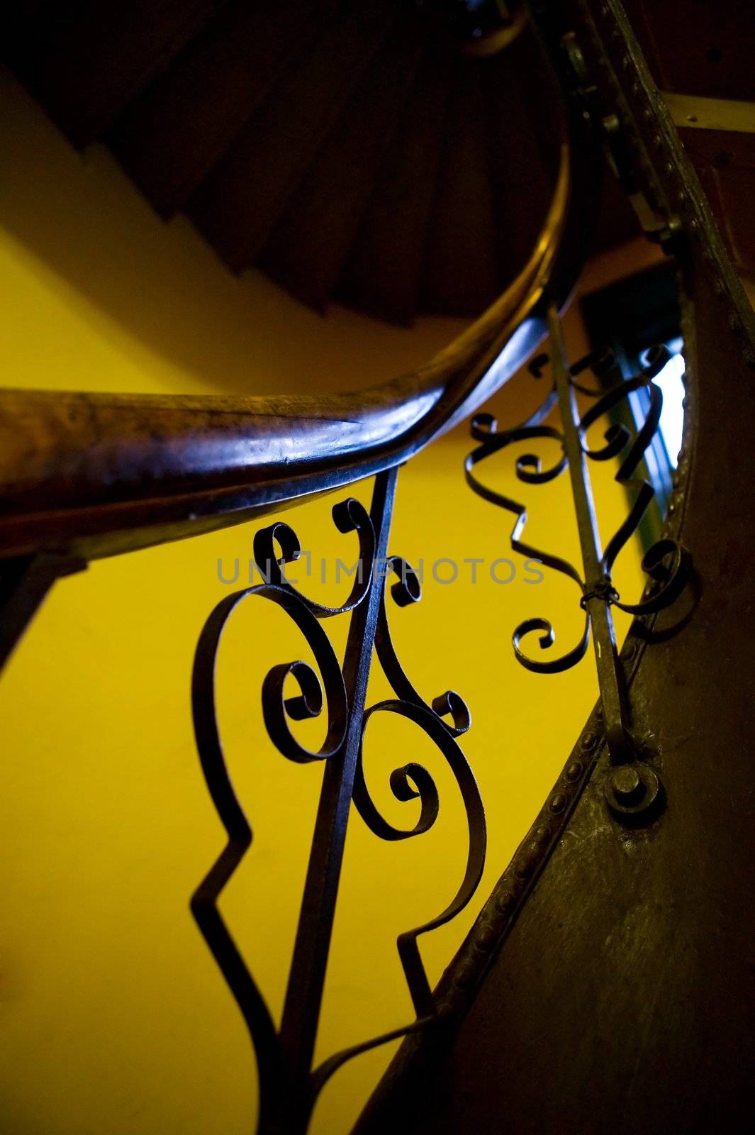 An abstract image of an old stairwell and railing with decorative iron.
