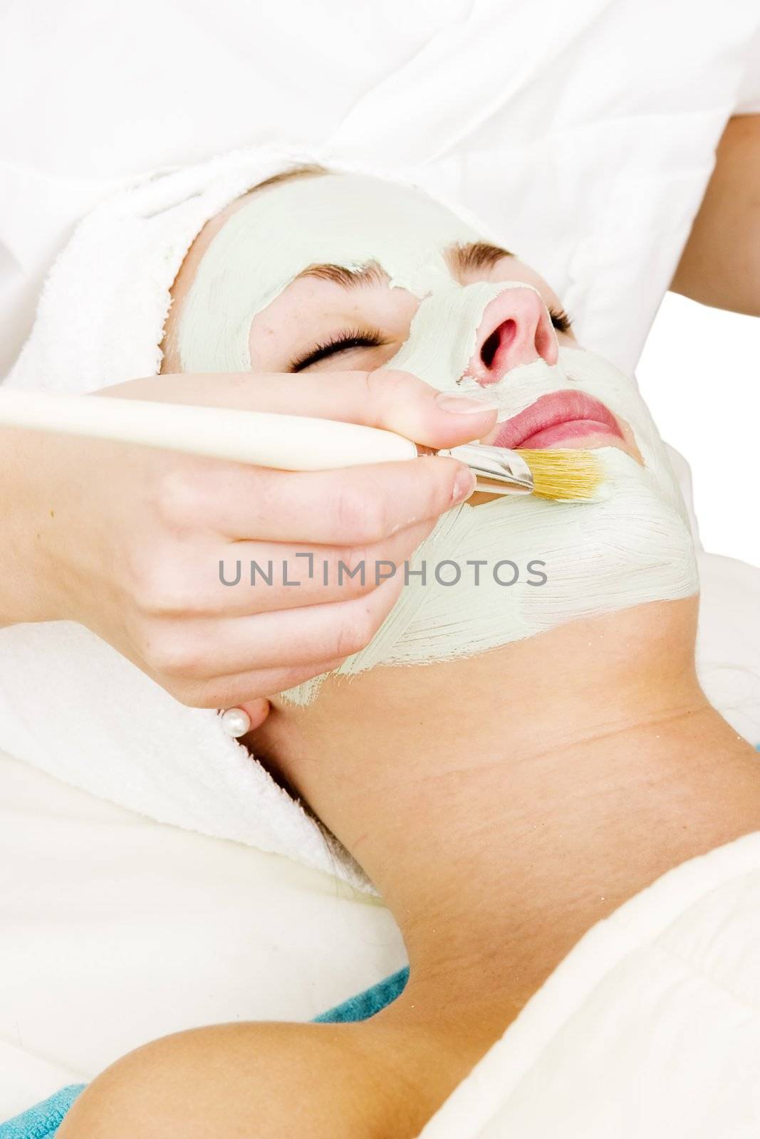 A detail image of a green apple mask being applied at a beauty spa.