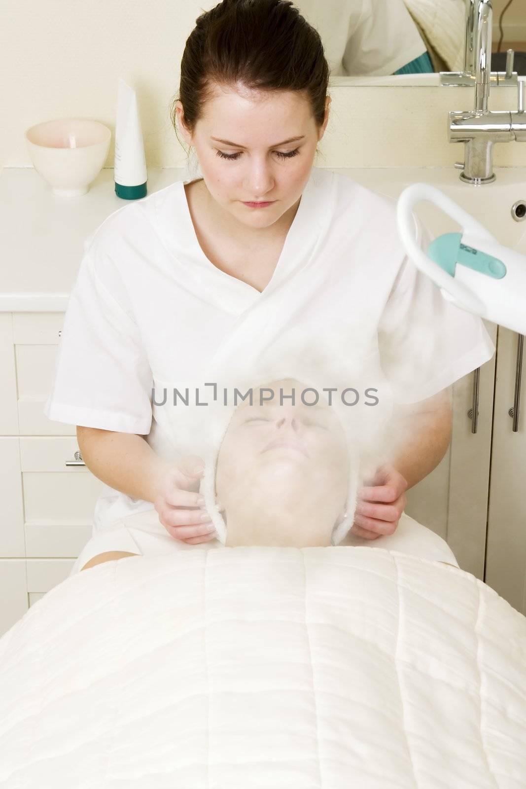 Steam treatment during a facial at a beauty spa.