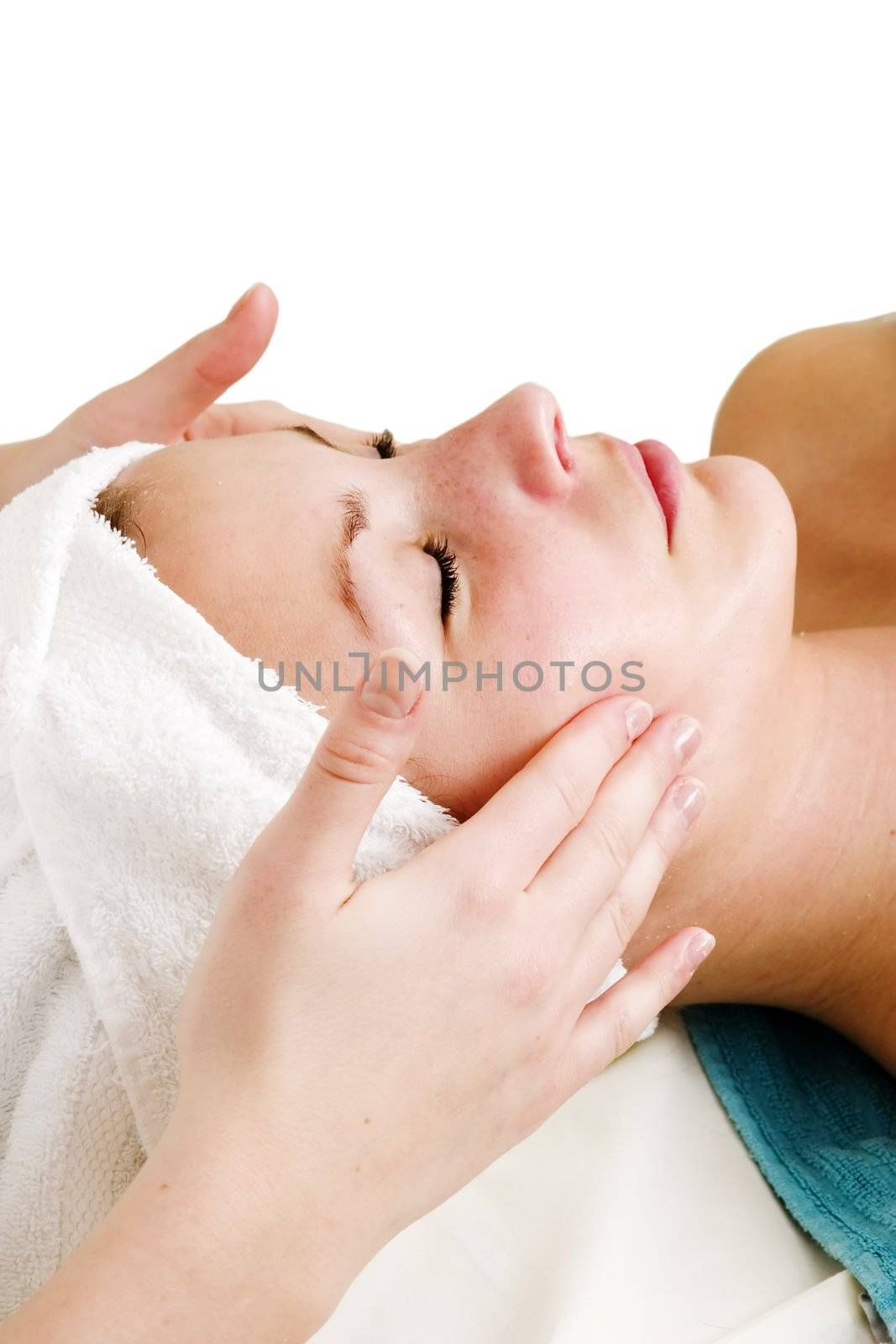 A face massage during a facial at a beauty spa with clipping path.