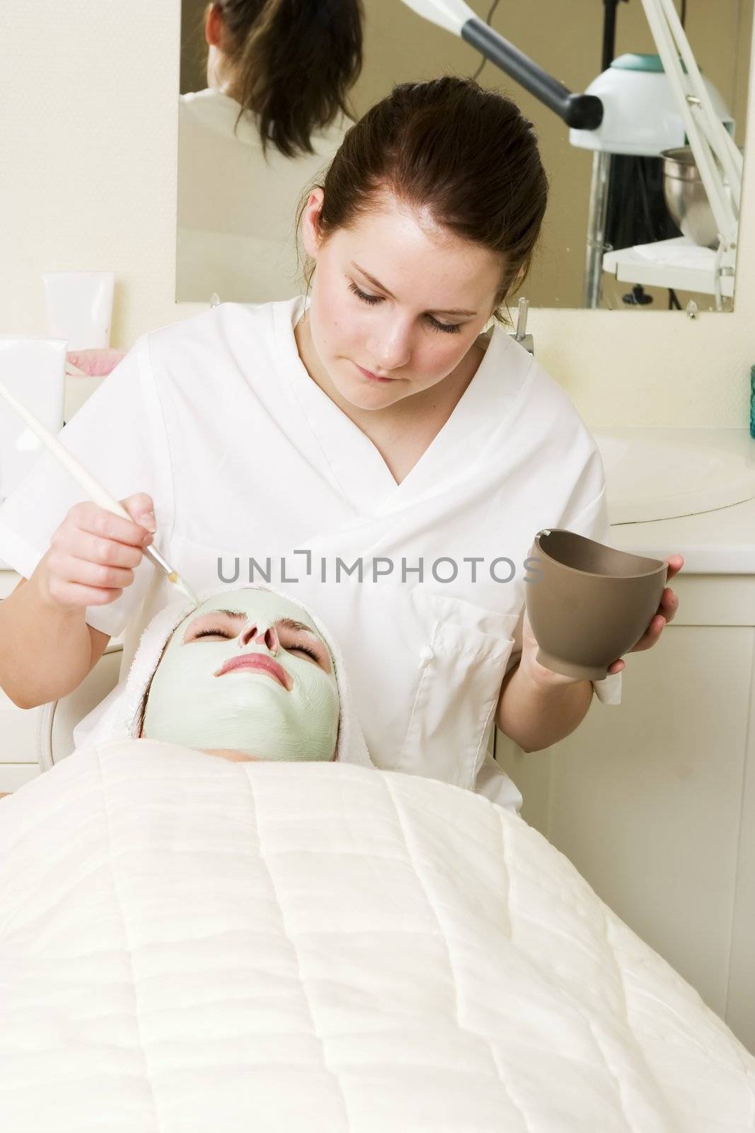 A detail image of a green apple mask being applied at a beauty spa.