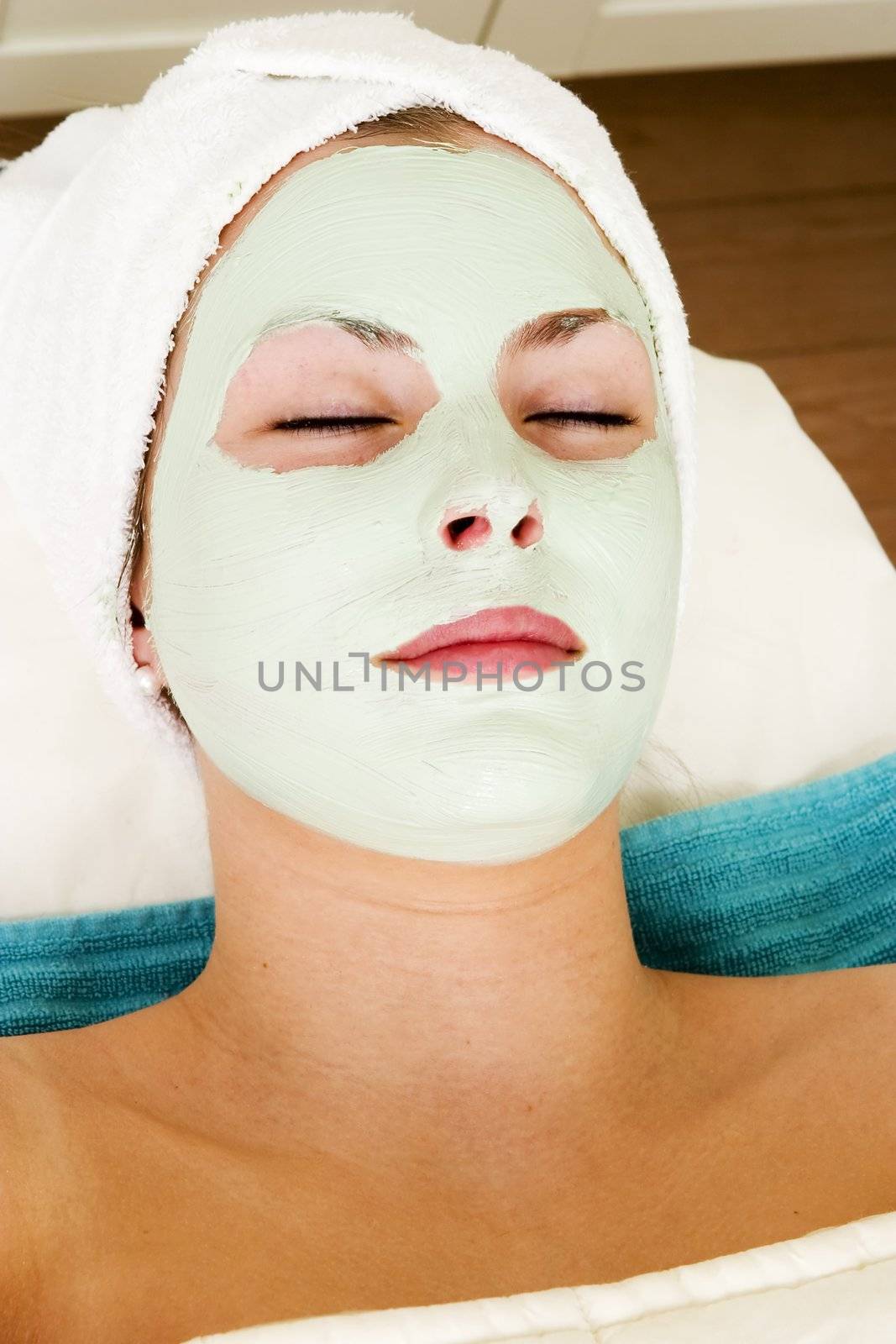 Relaxing with a green apple facial mask at a beauty spa.