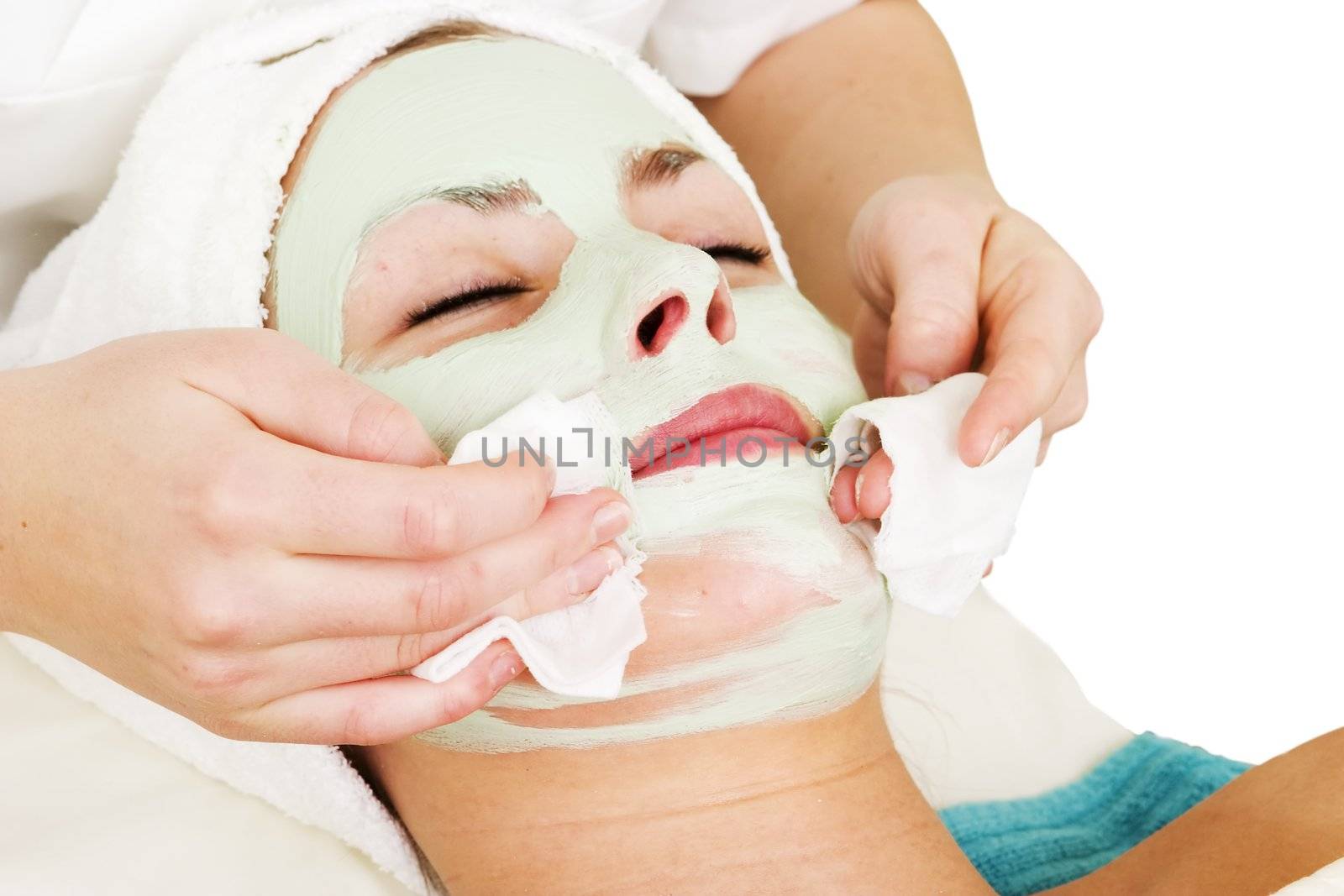 Detail of a facial mask treatment being wiped off the face.
