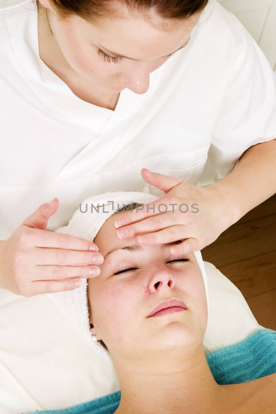 A woman receiving a facial massage at a beauty spa.