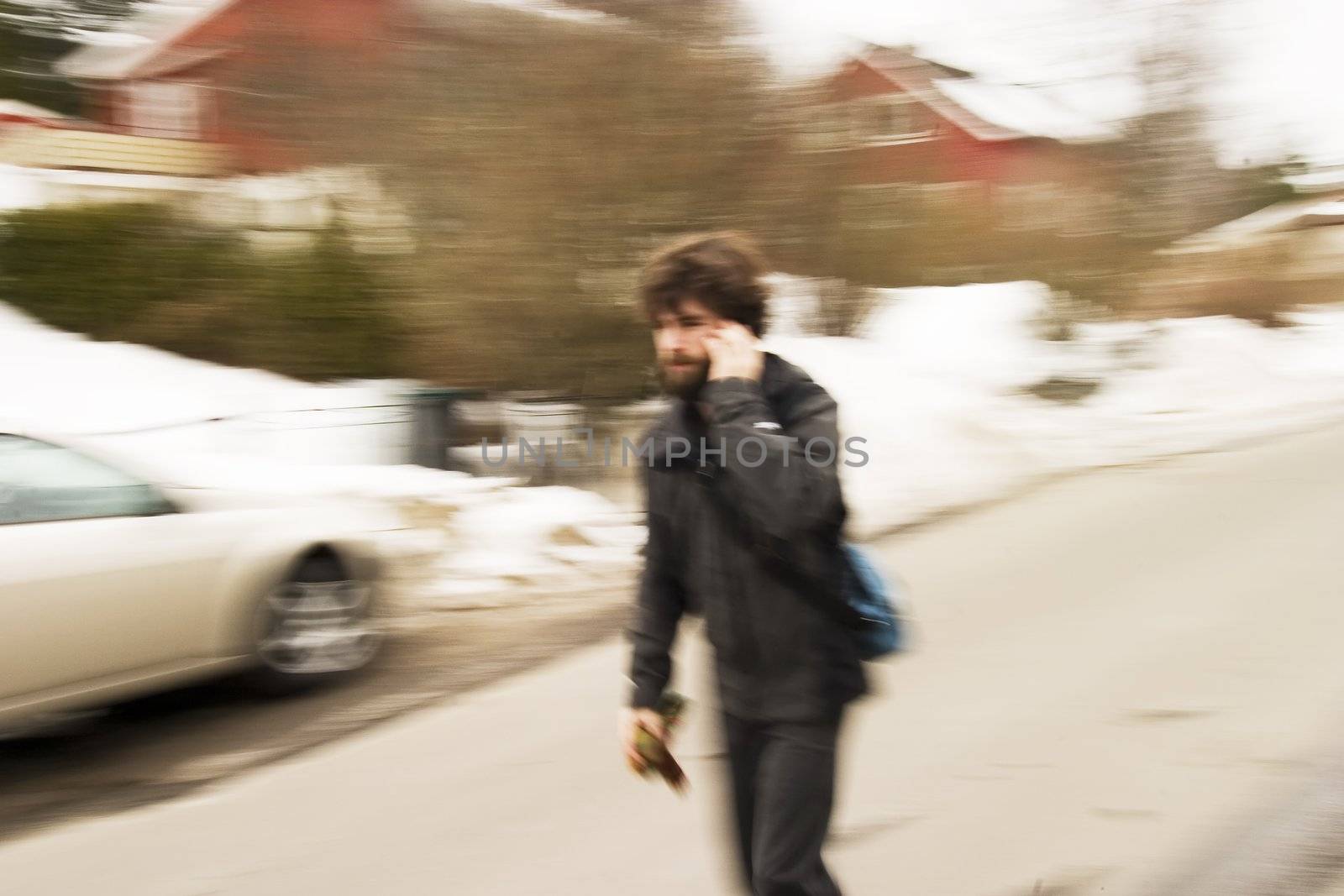A motion blur abstract of a person walking in a hurry talking on a cell phone, a late rushing concept image.