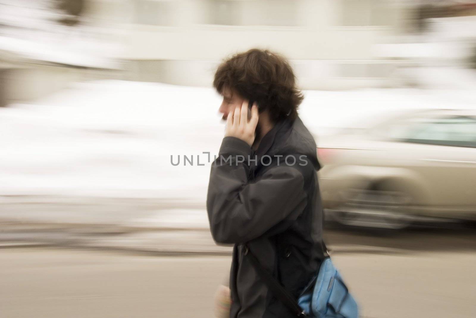 A motion blur abstract of a person walking in a hurry talking on a cell phone