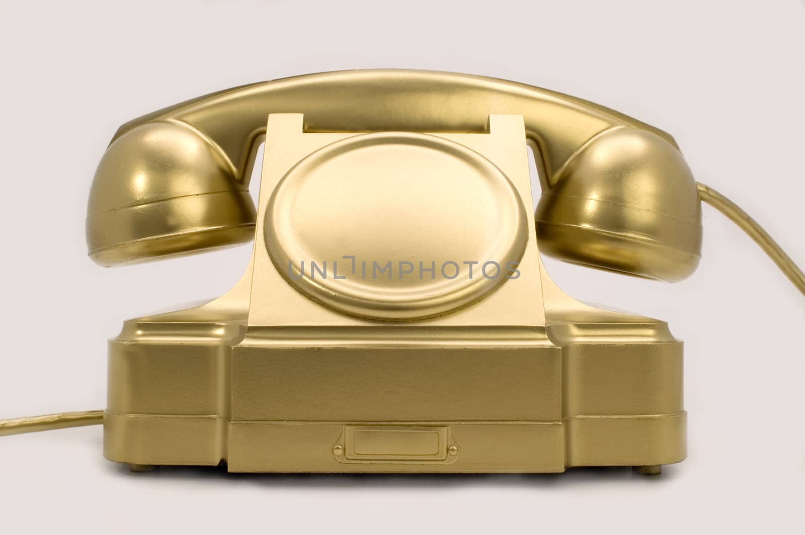 The telephone of gold colour on a white background.