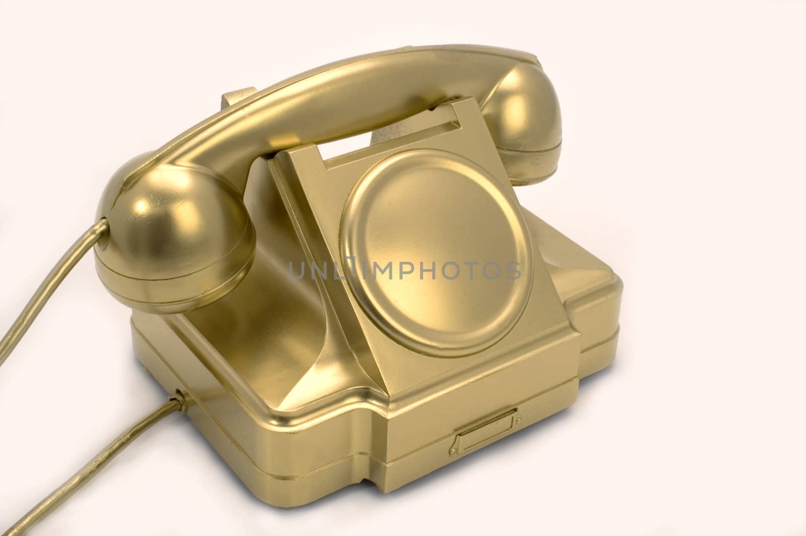 The telephone of gold colour on a white background.